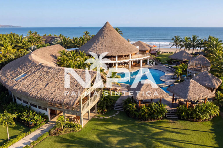Aerial view of a beach hotel with large-format synthetic palm thatch roofs, conical kiosks and a pool